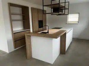 Keuken in Oudemirdum met strak design: wit kookeiland en zwevende houten nis