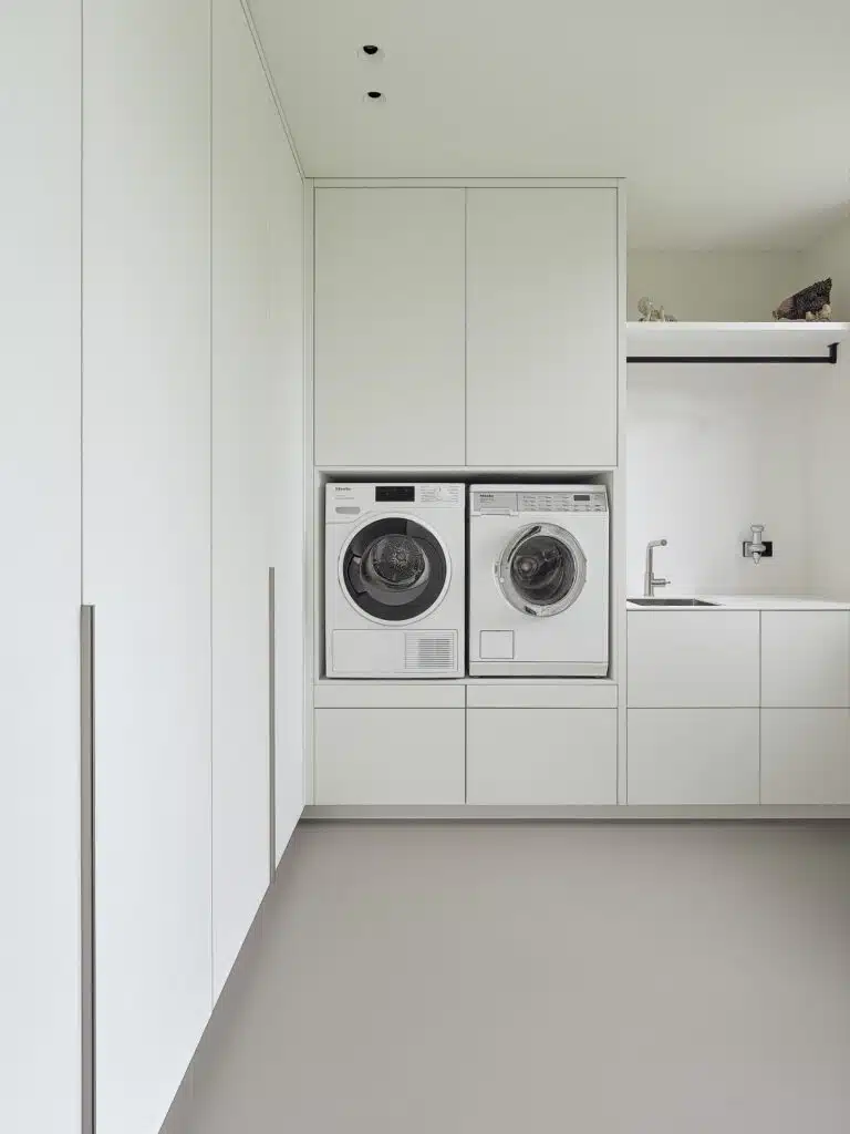trakke wasruimte met op maat gemaakte kasten en ingebouwde wasmachine