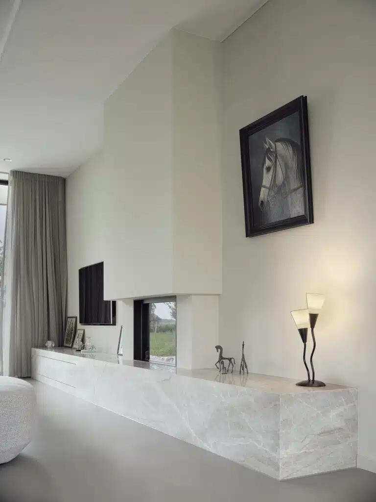 Biobased tv-meubel met geïntegreerde haard en marmerlook afwerking in een lichte woonkamer