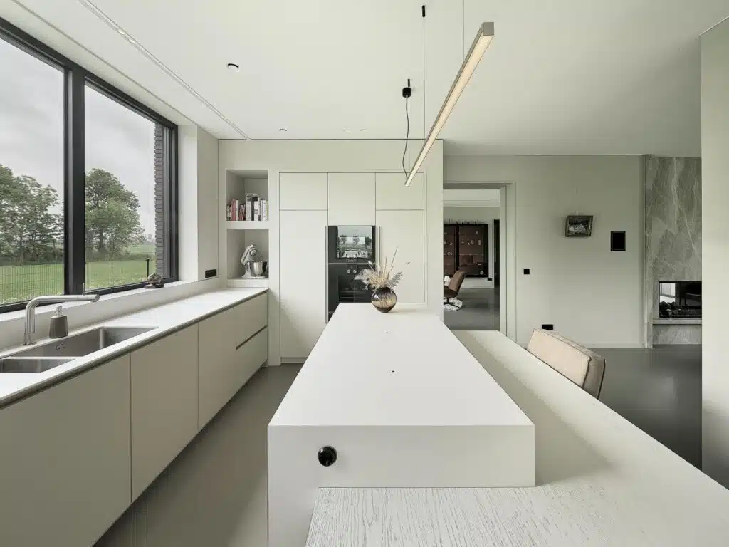 Lichte maatwerk keuken met kookeiland, hoge kasten en uitzicht op het Friese landschap, gerealiseerd in De Friese Meren.