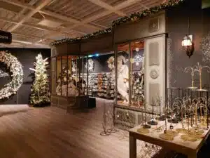 Interieur van een kerst boutique bij Intratuin met feestelijke verlichting, kerstbomen, decoratie en een etalage in klassieke stijl.